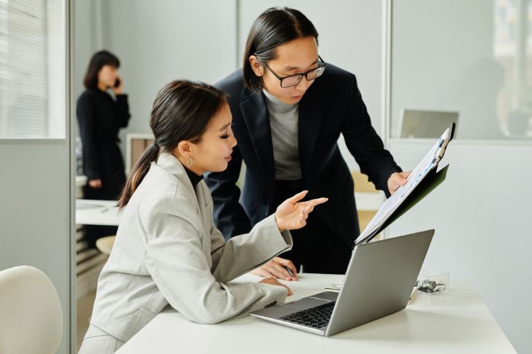 Mulheres olhando para relatórios, no escritório.